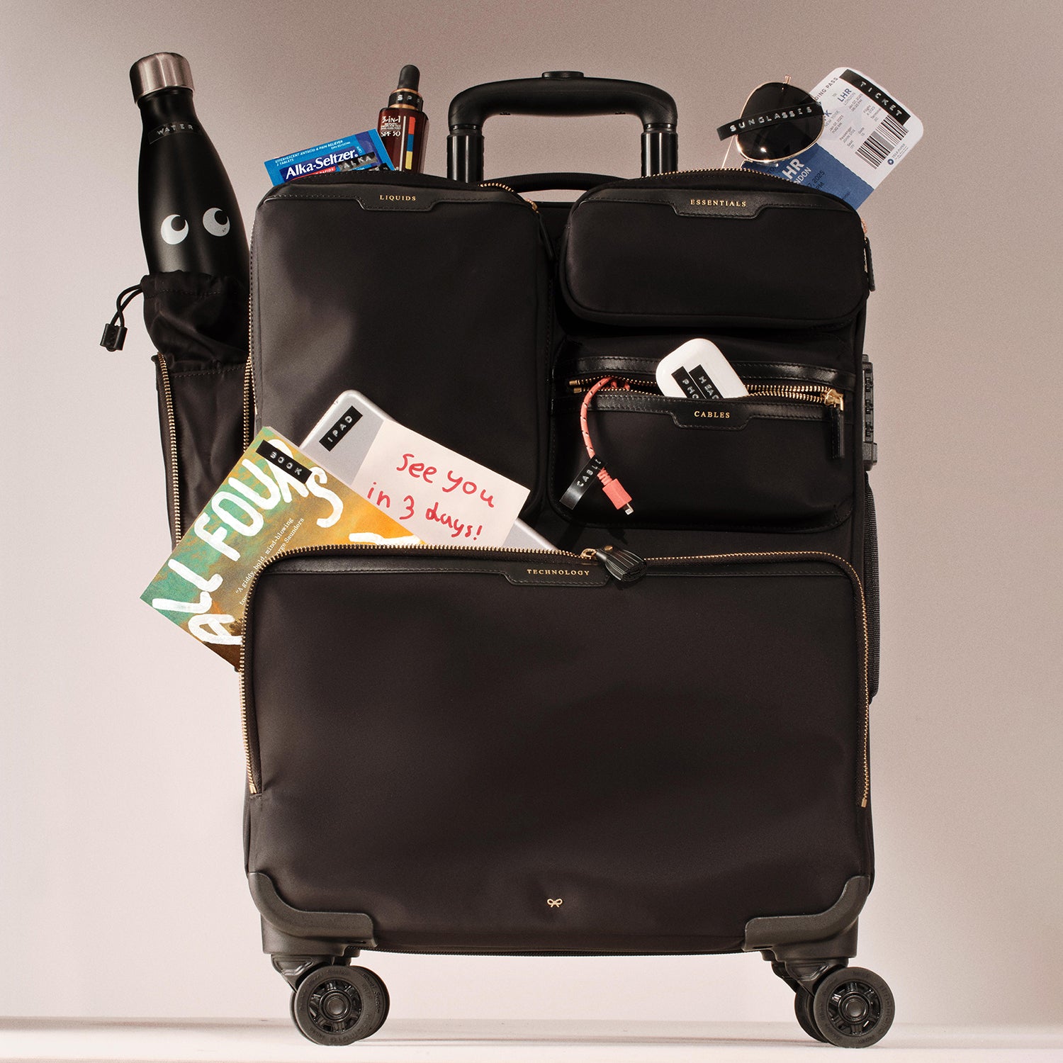 Short-Haul Suitcase -

          
            Econyl® Regenerated Nylon in Black -
          

          Anya Hindmarch US
