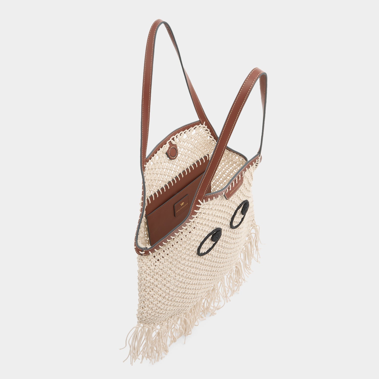 Macramé tote bag handcrafted from natural cotton cord and embroidered Eyes motif with eco-leather top handles and detachable long crossbody strap by Anya Hindmarch