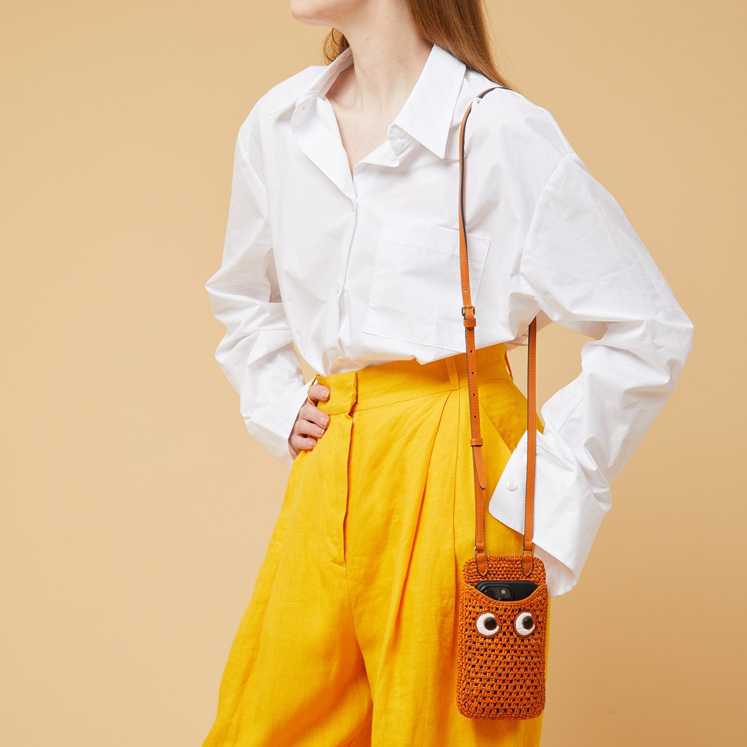 Eyes Phone Pouch on Strap -

                  
                    Raffia in Clementine -
                  

                  Anya Hindmarch US
